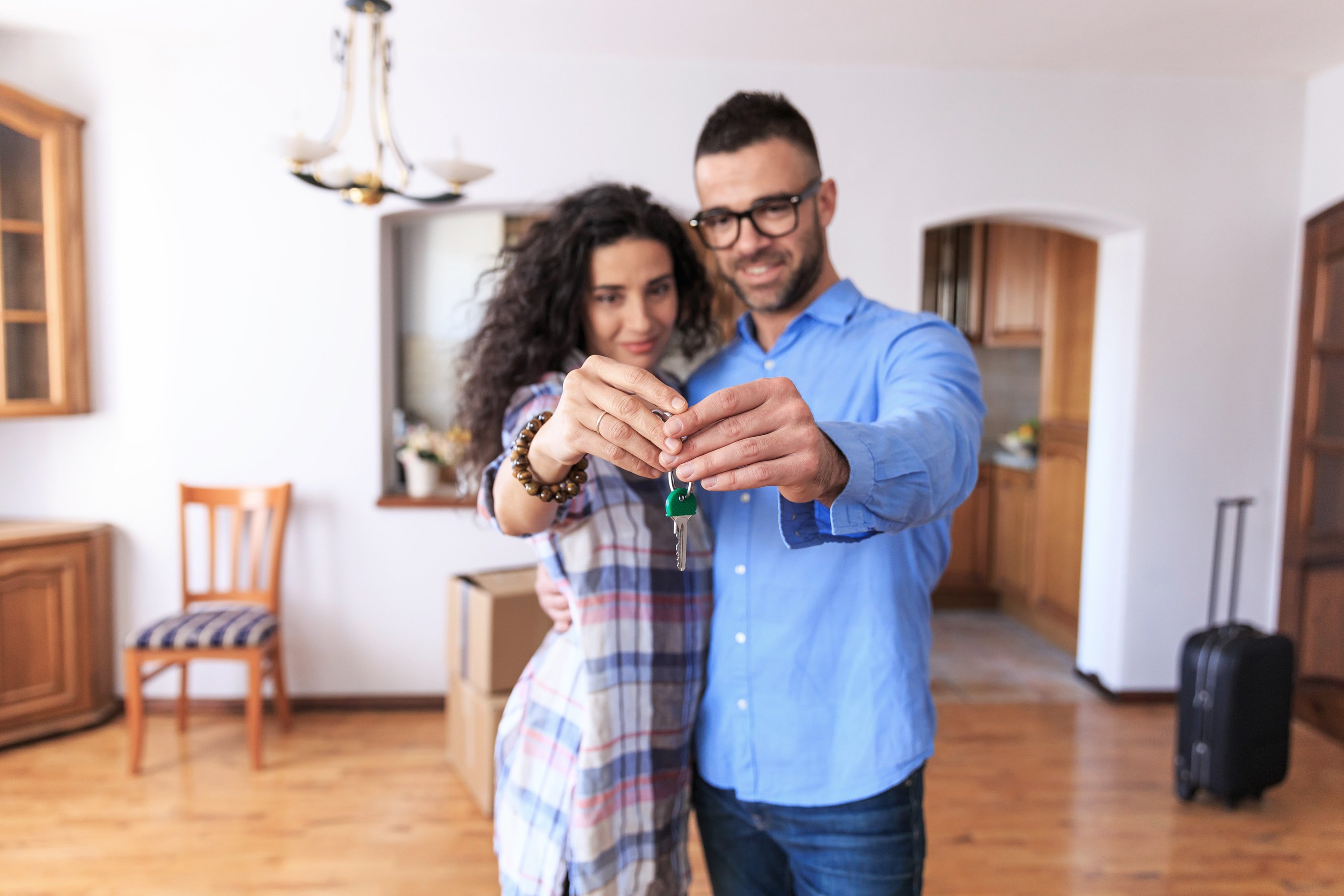 Couple cheerful home owners holding a key